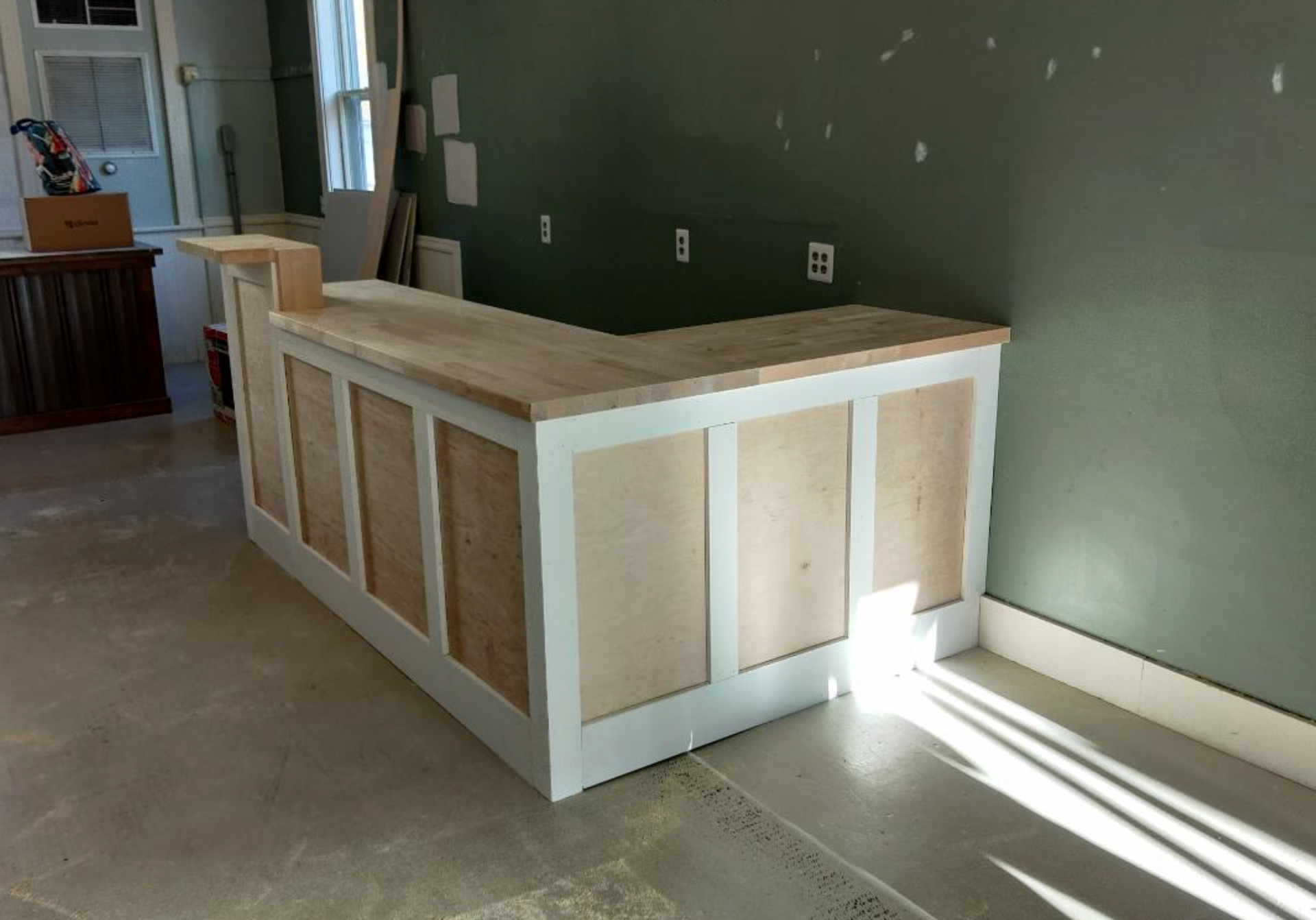 A wooden counter in a room with a green wall