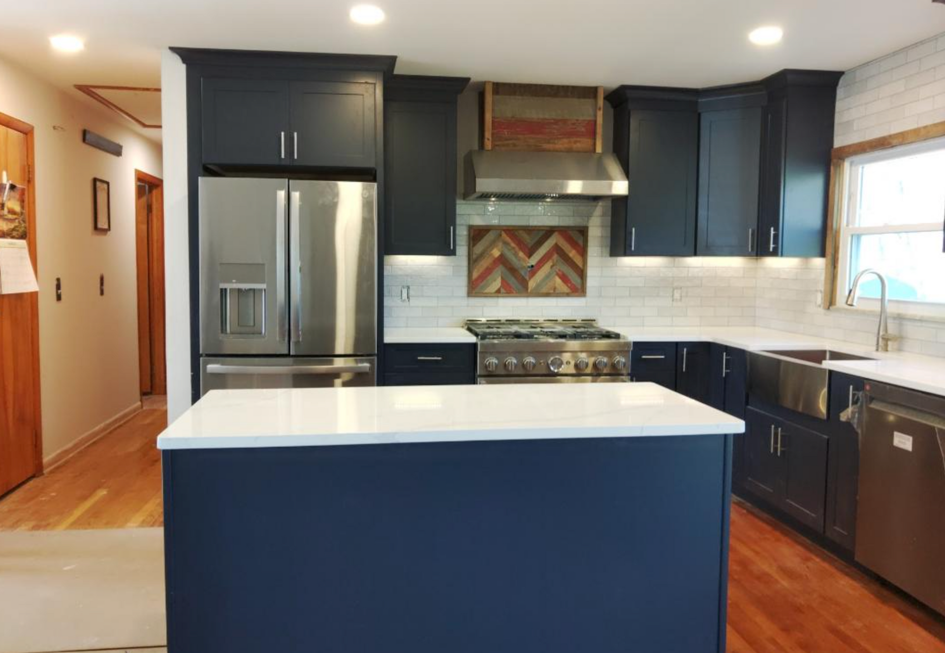 A kitchen with black cabinets and stainless steel appliances