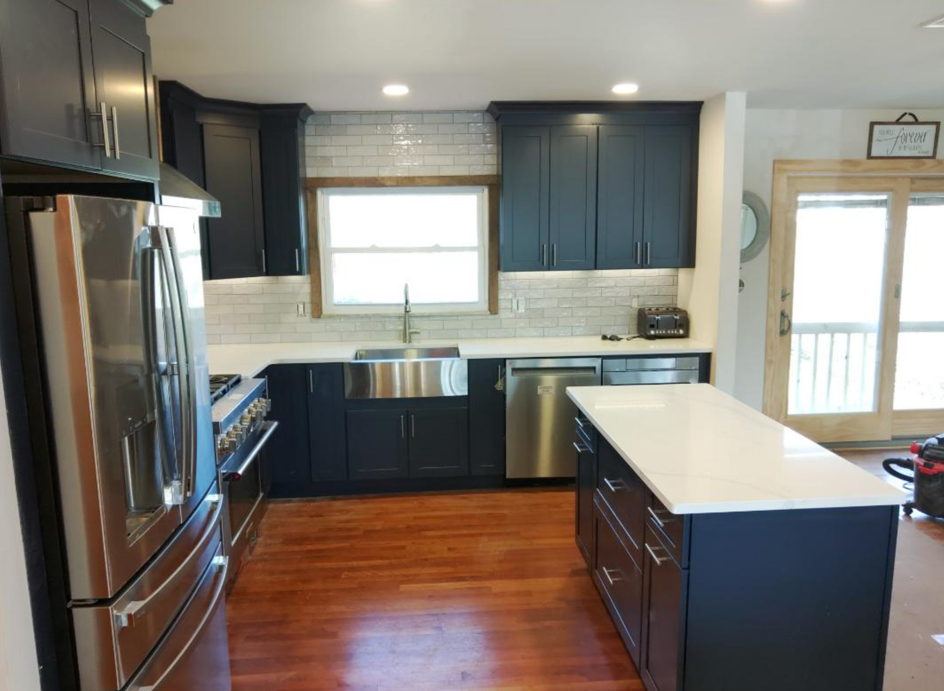 A kitchen with black cabinets and stainless steel appliances