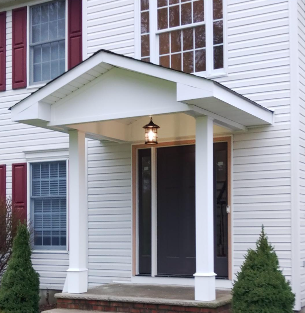 A white house with red shutters and a porch