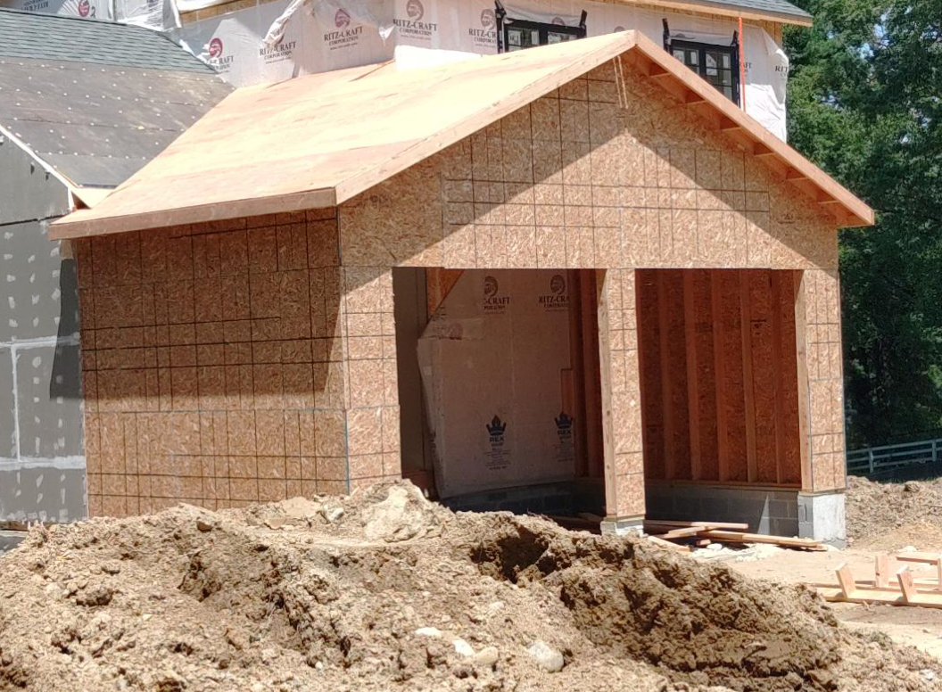 A house is being built with plywood and a roof