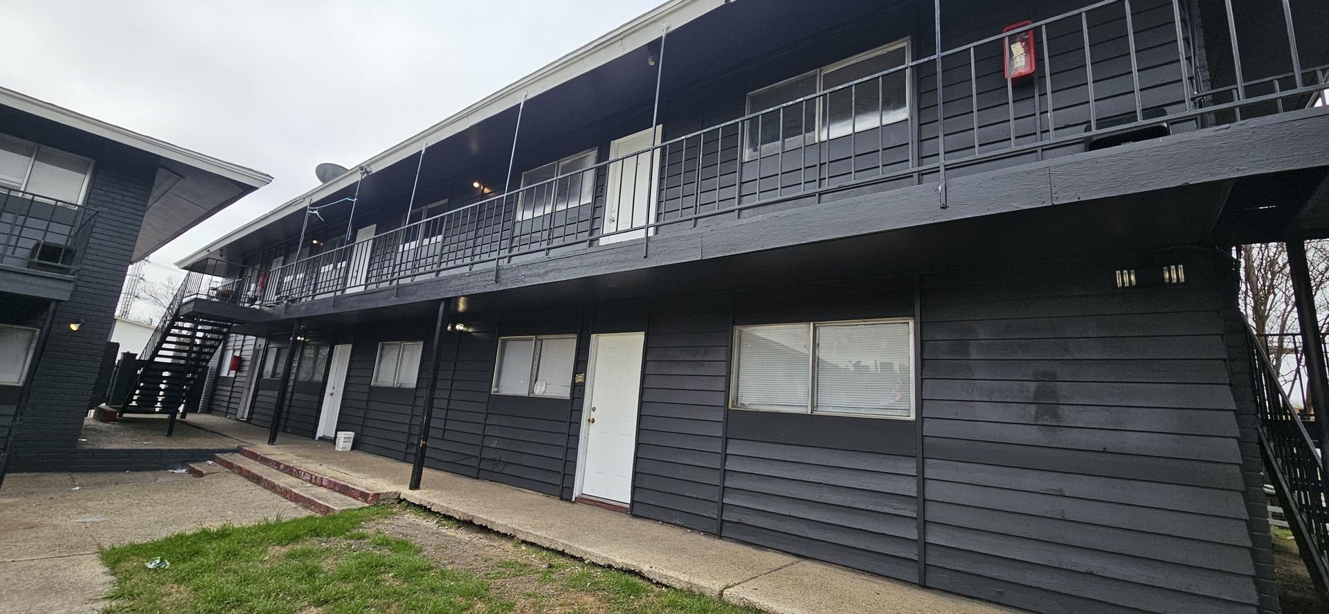 A large black apartment building with a lot of windows and balconies.