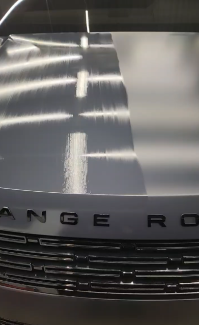 Close-up of a silver Range Rover's hood with the word