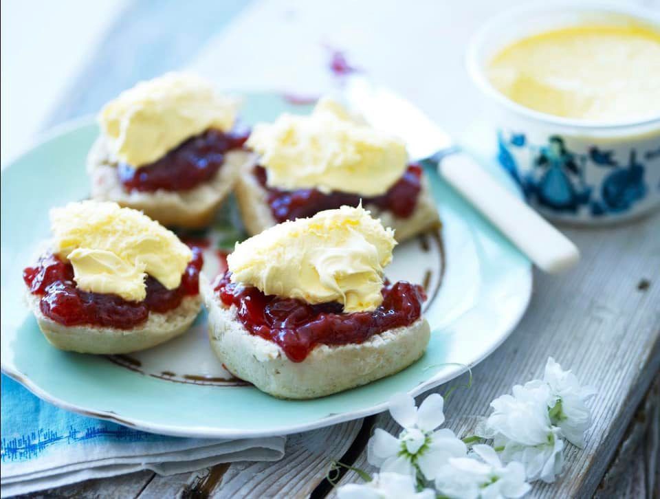 Three scones with jam and butter on blue plate