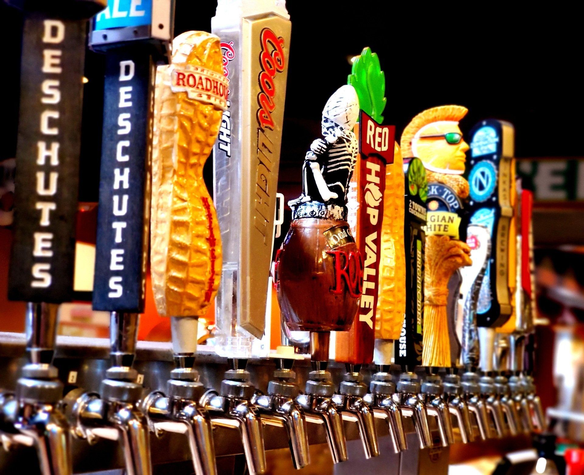 A row of beer taps with one that says deschutes on it