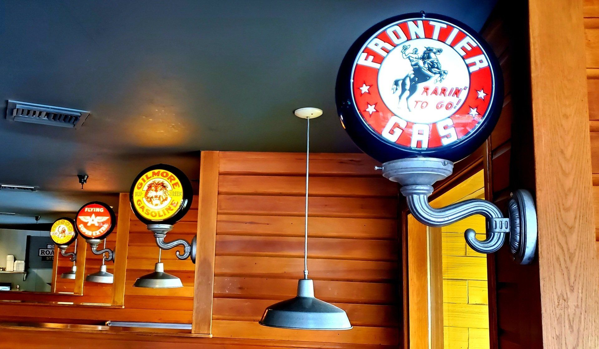 A frontier gas sign hangs from the ceiling of a restaurant