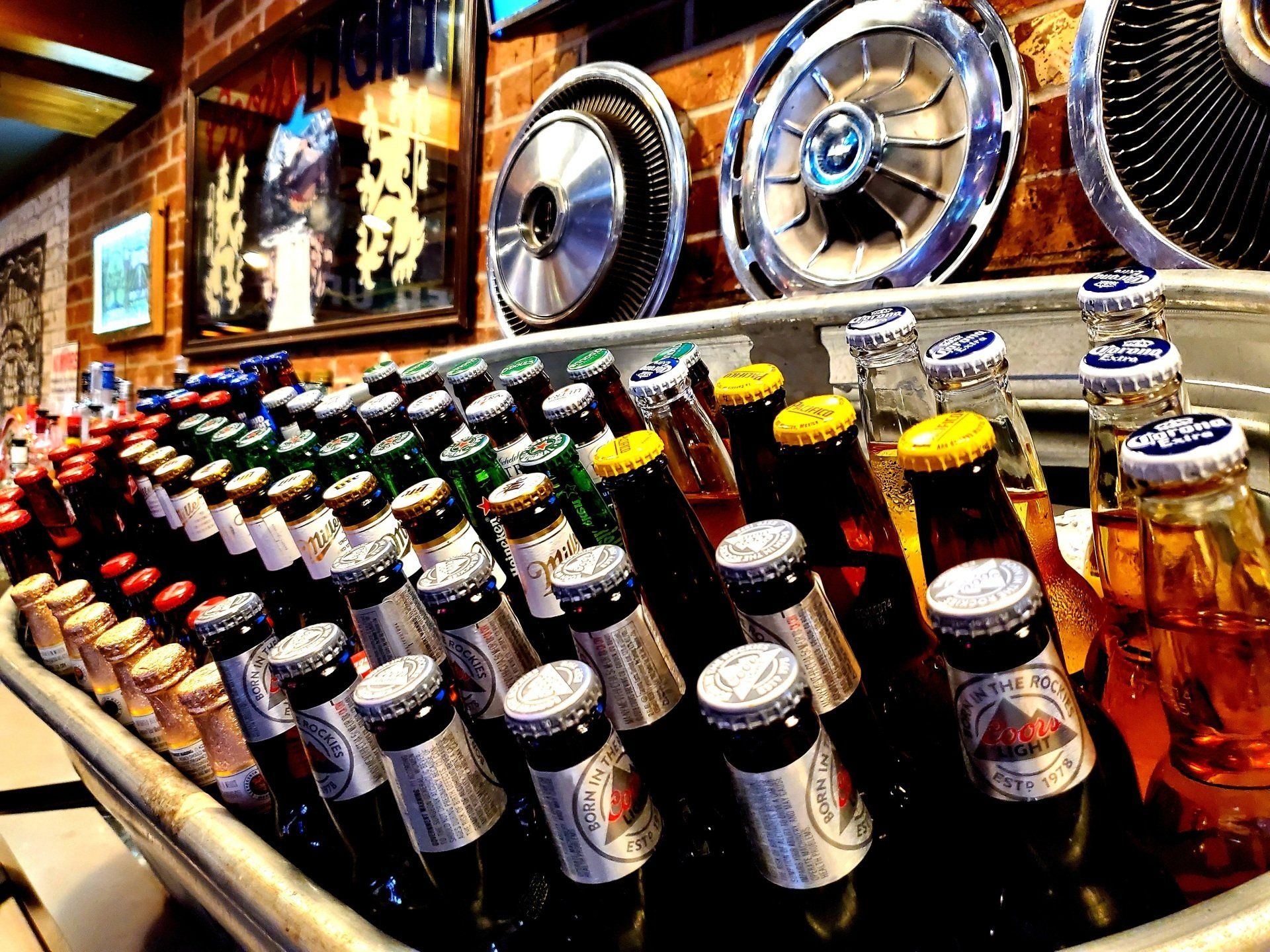 A bunch of beer bottles are lined up in a cooler
