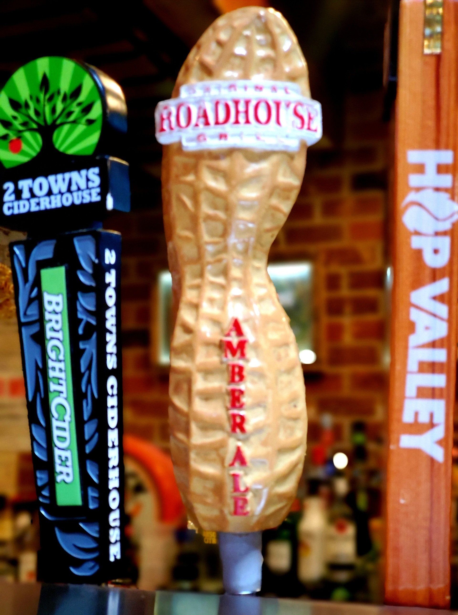 A peanut shaped beer tap with the word roadhouse on it