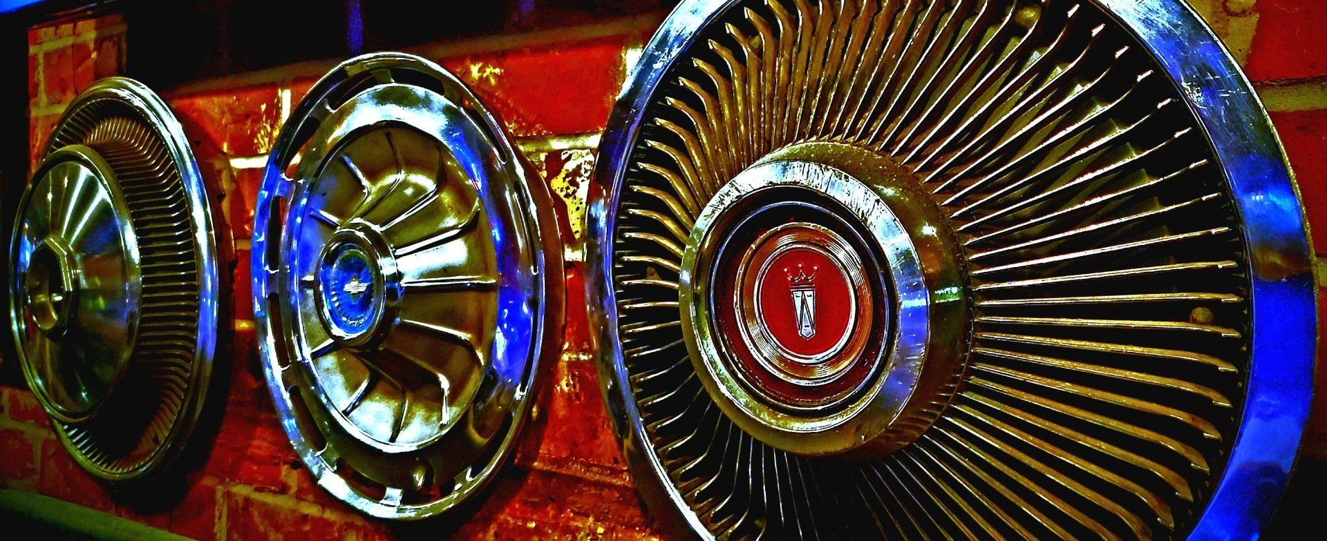 A row of wheels are lined up on a wall.