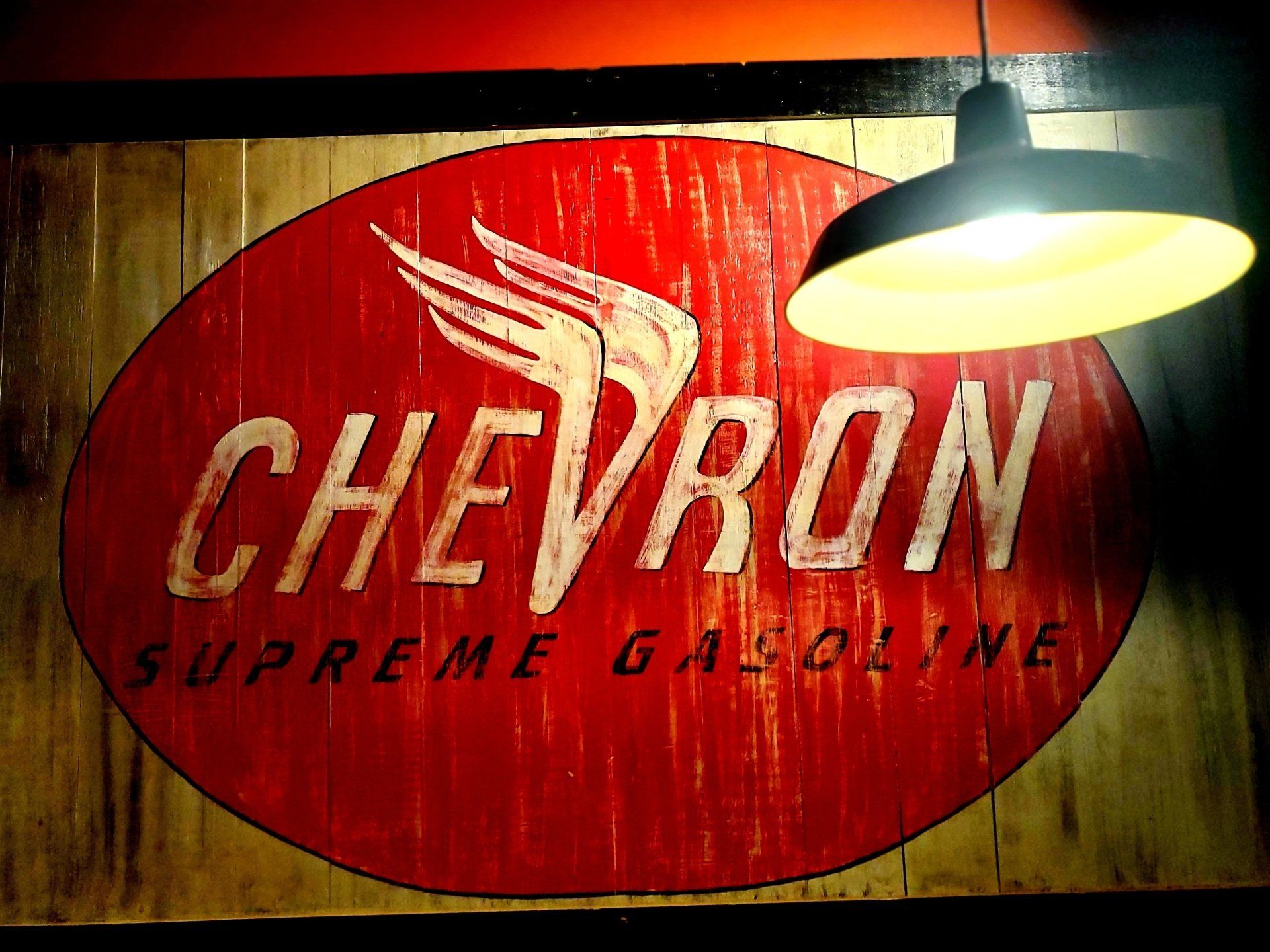 A sign that says chevron supreme gasoline on it