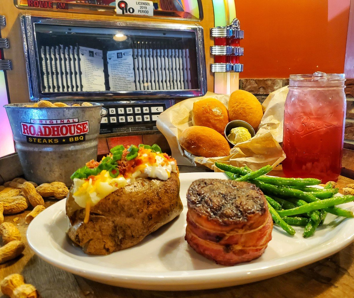 A plate of food with a drink and a jukebox in the background.