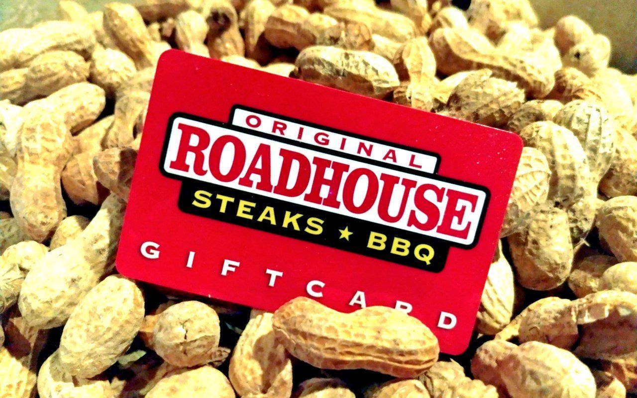 A red roadhouse gift card is sitting on a pile of peanuts