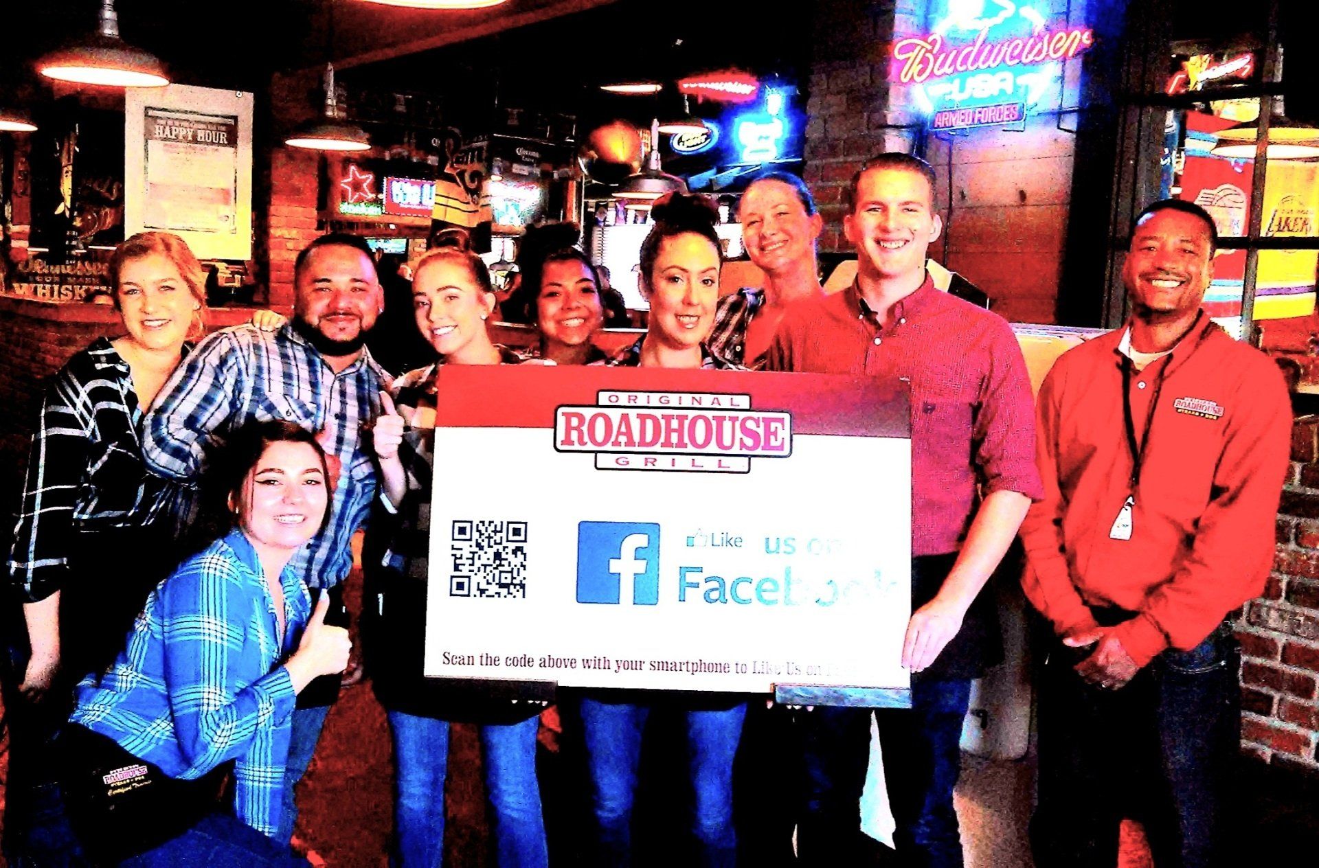 A group of people standing in front of a sign that says roadhouse