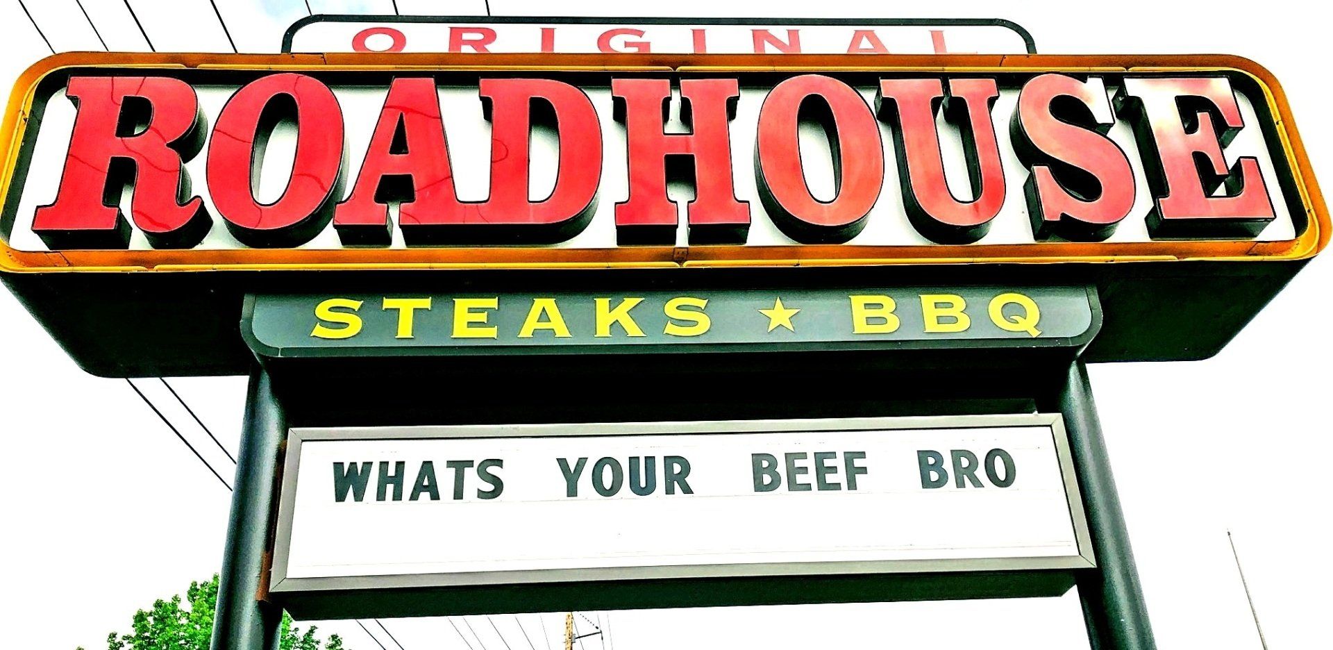A sign for roadhouse steaks and bbq says whats your beef bro