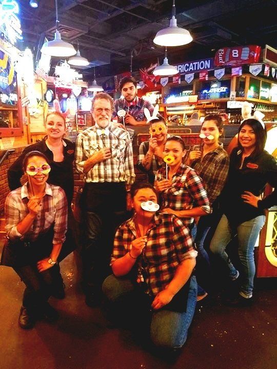 A group of people posing for a picture in front of a sign that says vacation