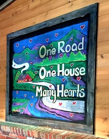 A sign that says one road one house many hearts