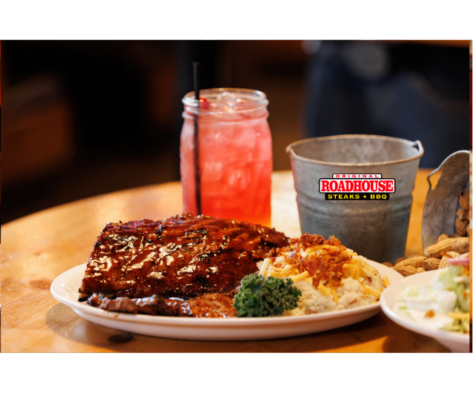 A plate of food with ribs , mashed potatoes , broccoli and a drink on a table.