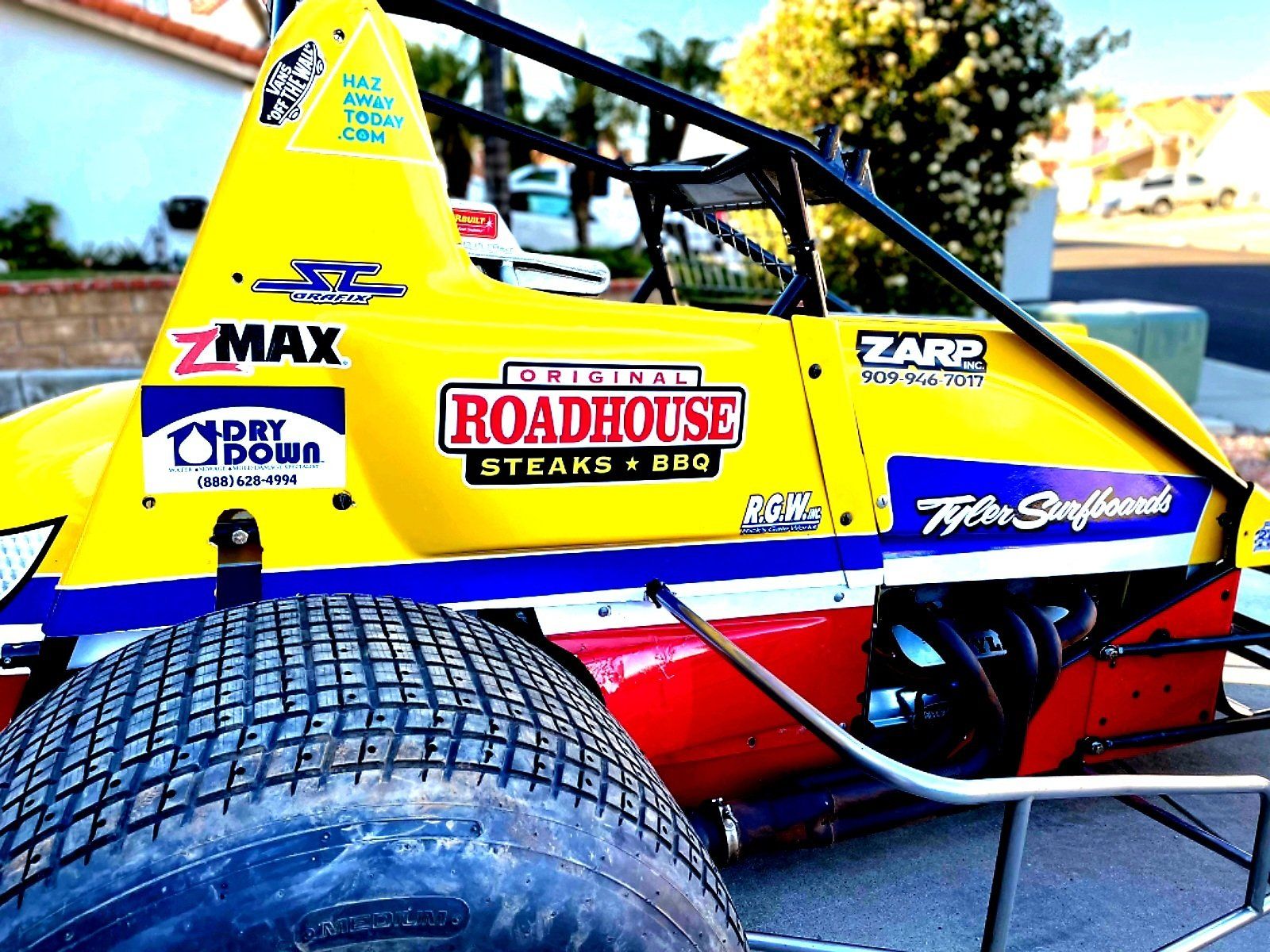 A yellow race car with the word roadhouse on the side