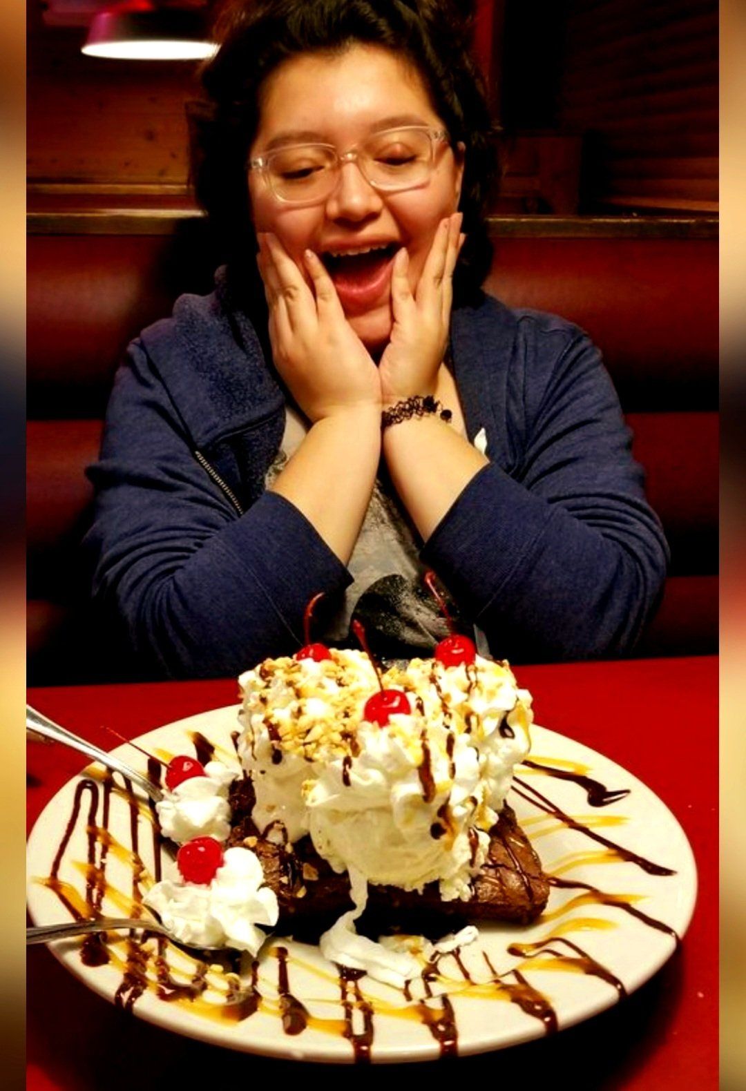 A woman is sitting in front of a plate of dessert