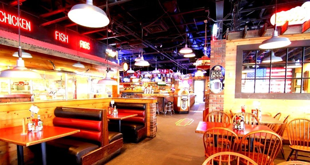 A restaurant with tables and chairs and a sign that says chicken.
