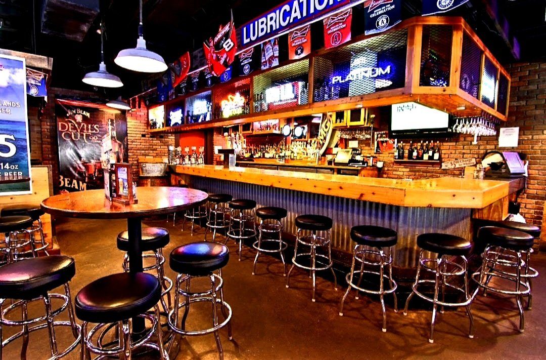 A bar with tables and stools and a long bar.