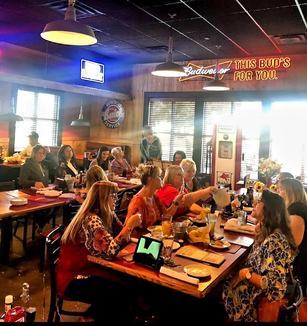 A group of people are sitting at tables in a restaurant.