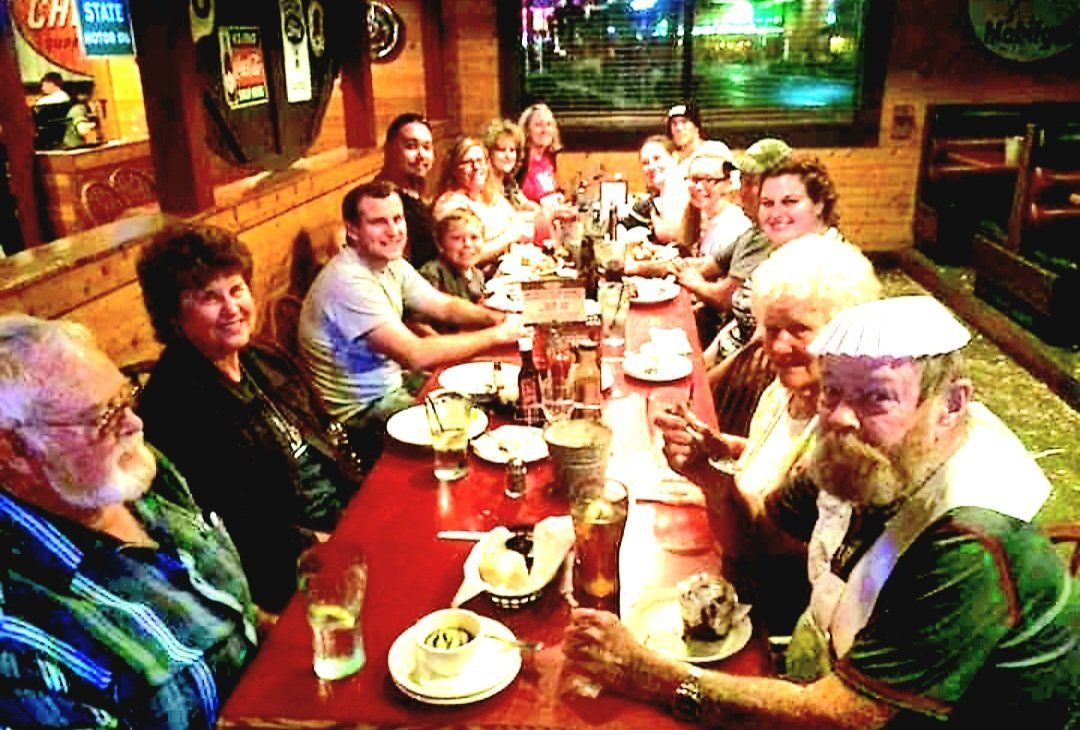 A group of people are sitting at a long table in a restaurant