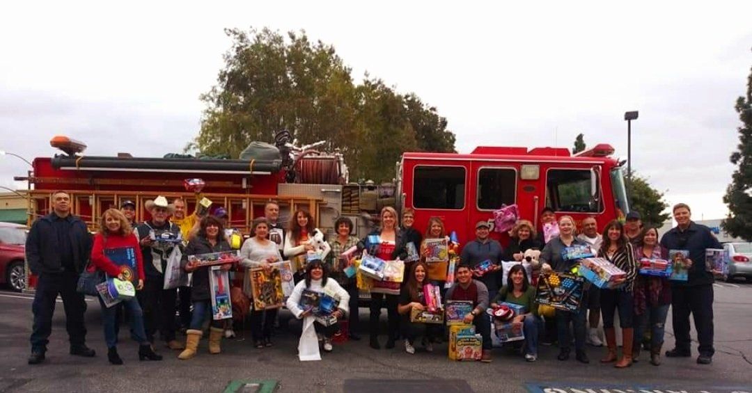 A group of people are posing for a picture in front of a fire truck.