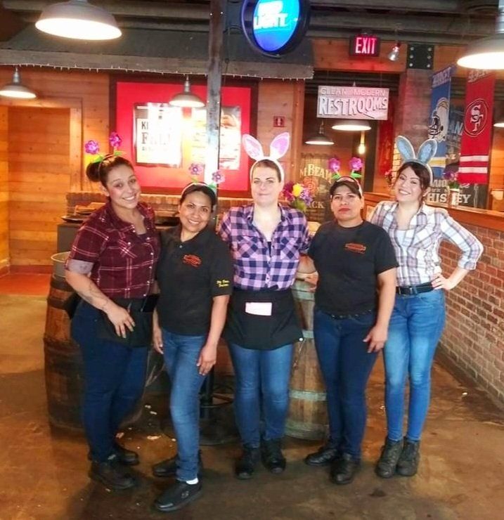 A group of women standing in front of a sign that says restrooms