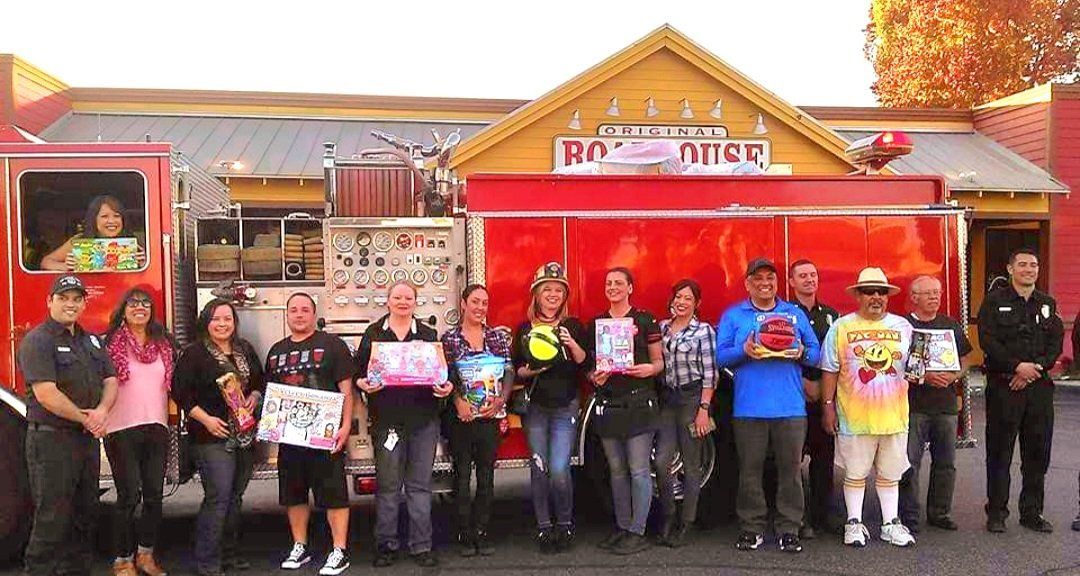A group of people are standing in front of a fire truck.
