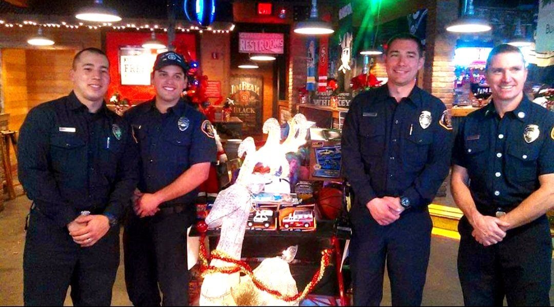 A group of police officers standing in front of a christmas tree