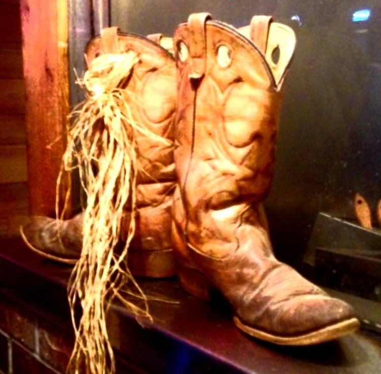 A pair of brown cowboy boots sitting on a shelf