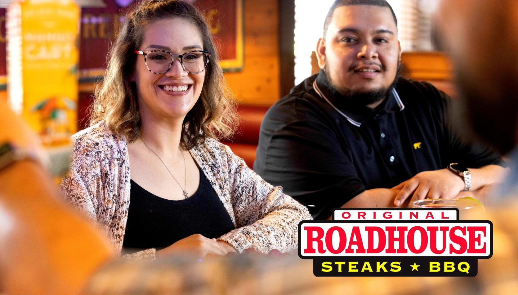 A man and a woman are sitting at a table in a restaurant.