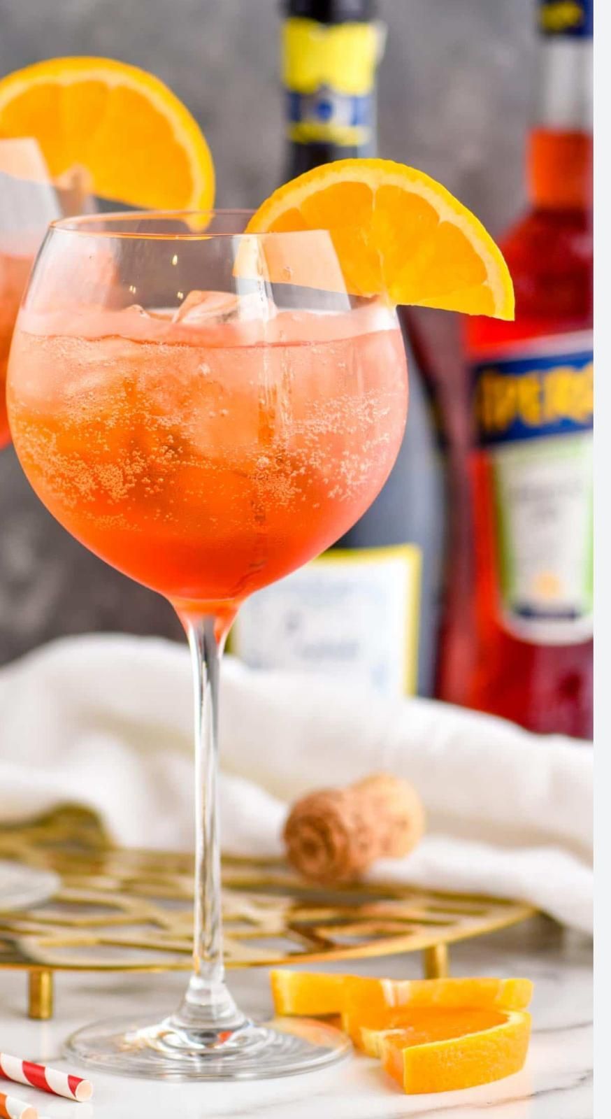 Cocktail all'arancia in un bicchiere alto, guarnito con una fetta d'arancia.