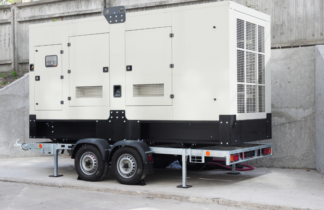 A generator is sitting on a trailer in a parking lot.