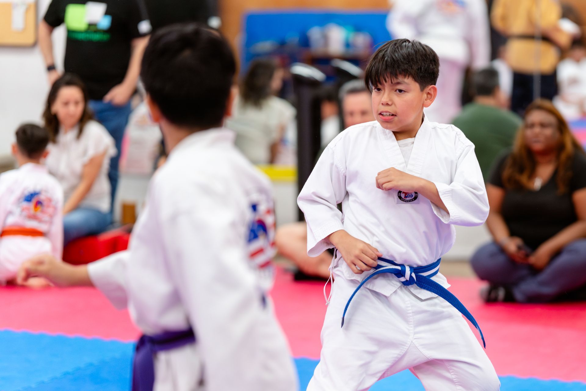 Taekwondo students wearing white uniforms and sparing.
