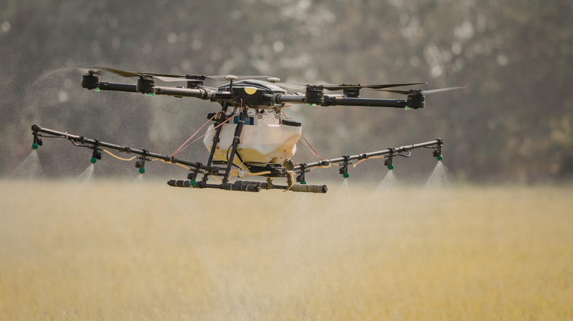 Agricultural drone spraying crops in a field.