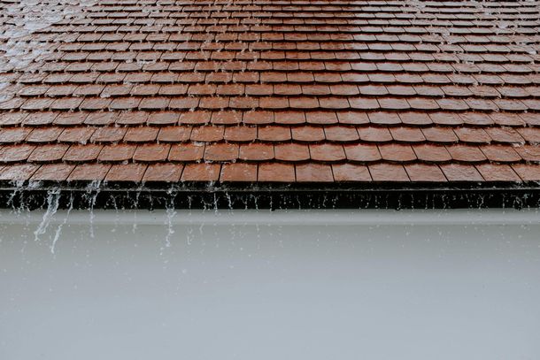 The rain is falling on the roof of a house.