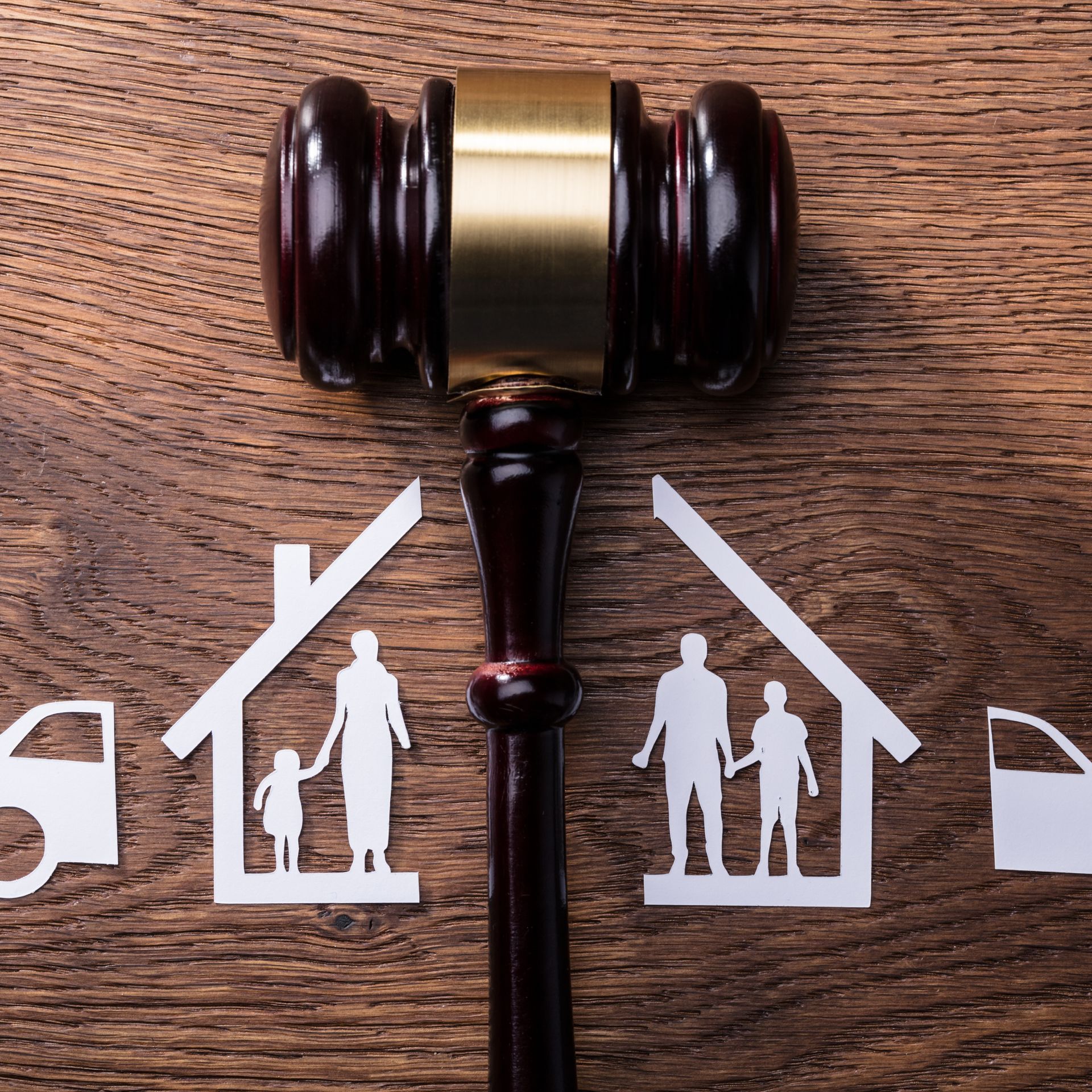 Judge’s gavel over house icons on wood background, suggesting a family law or custody decision