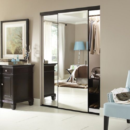 A bedroom with a large mirrored closet door
