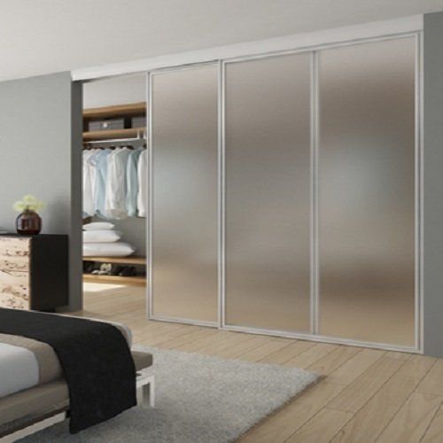 A bedroom with sliding glass doors leading to a walk in closet