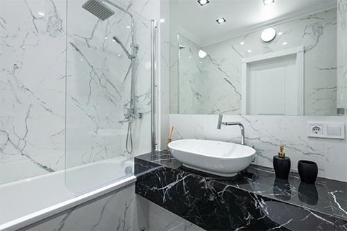 A bathroom with a sink , bathtub , shower and mirror.