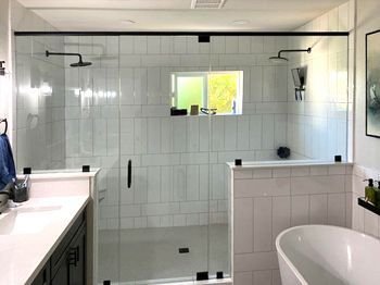 A bathroom with a walk in shower and a bathtub.