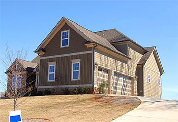 A large brown house with a blue garage door
