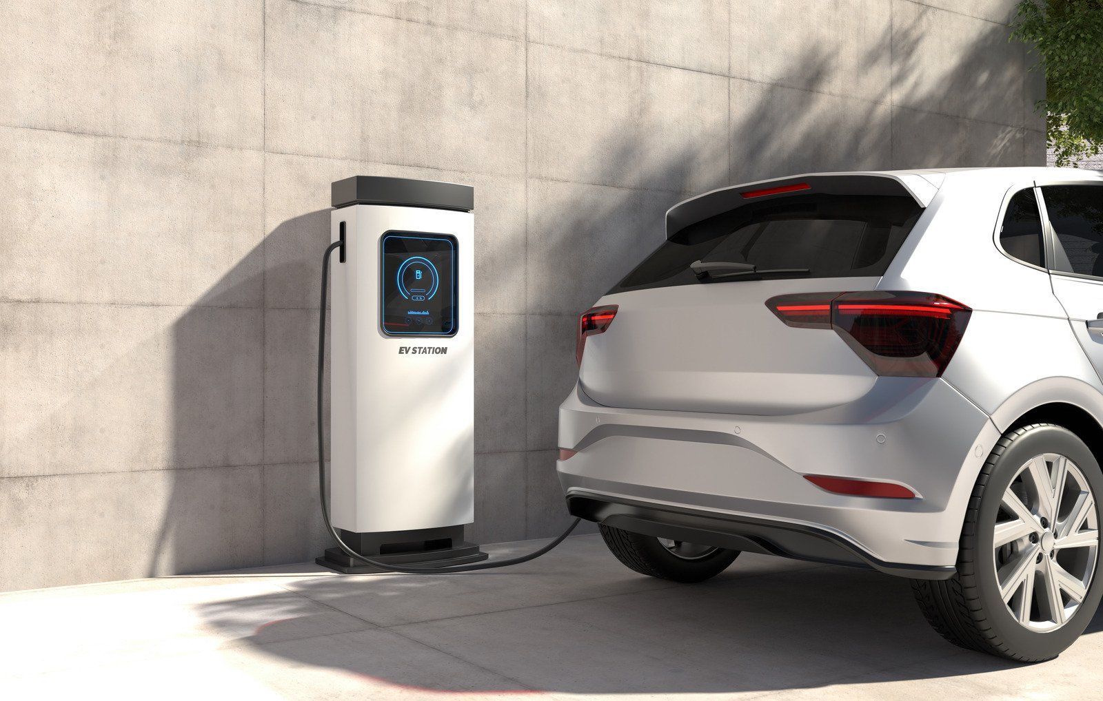 An electric car charging station connected to a silver hatchback parked in a driveway.