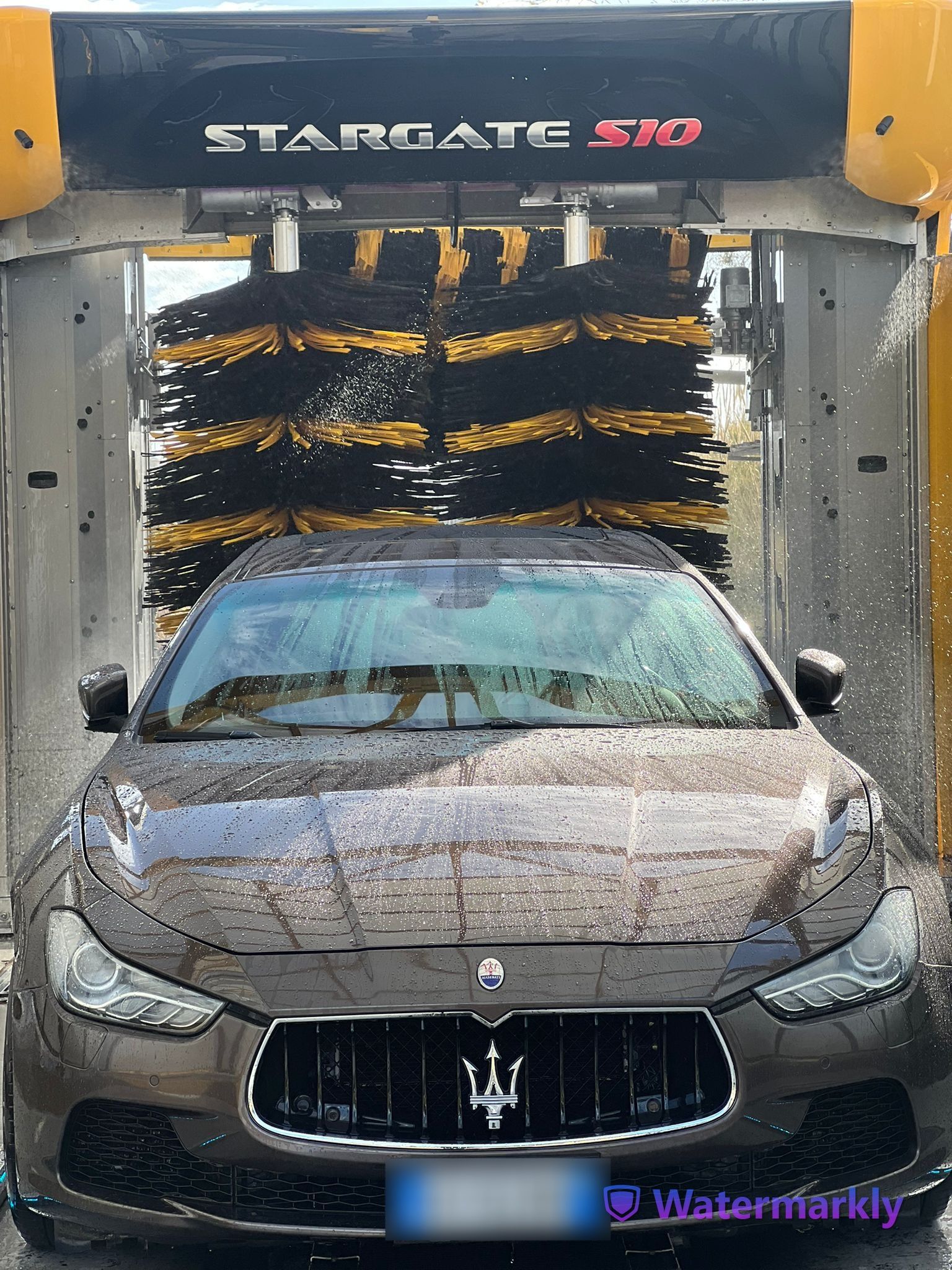A maserati is being washed in a car wash
