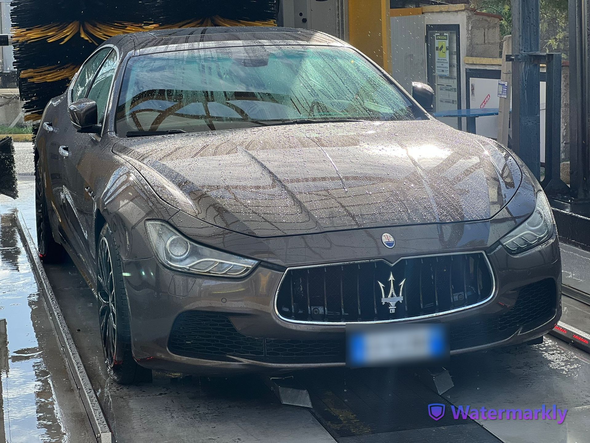 A maserati is being washed in a car wash