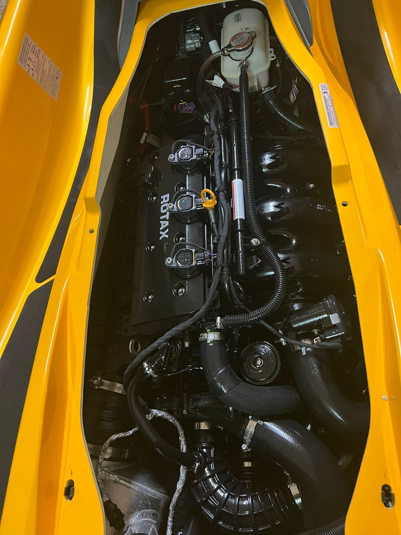 The inside of a yellow vehicle with a black engine