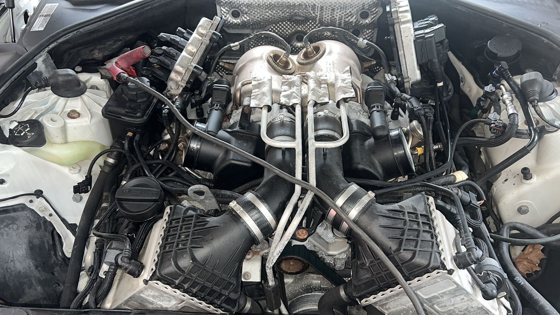 A close up of a car engine with a lot of wires coming out of it.