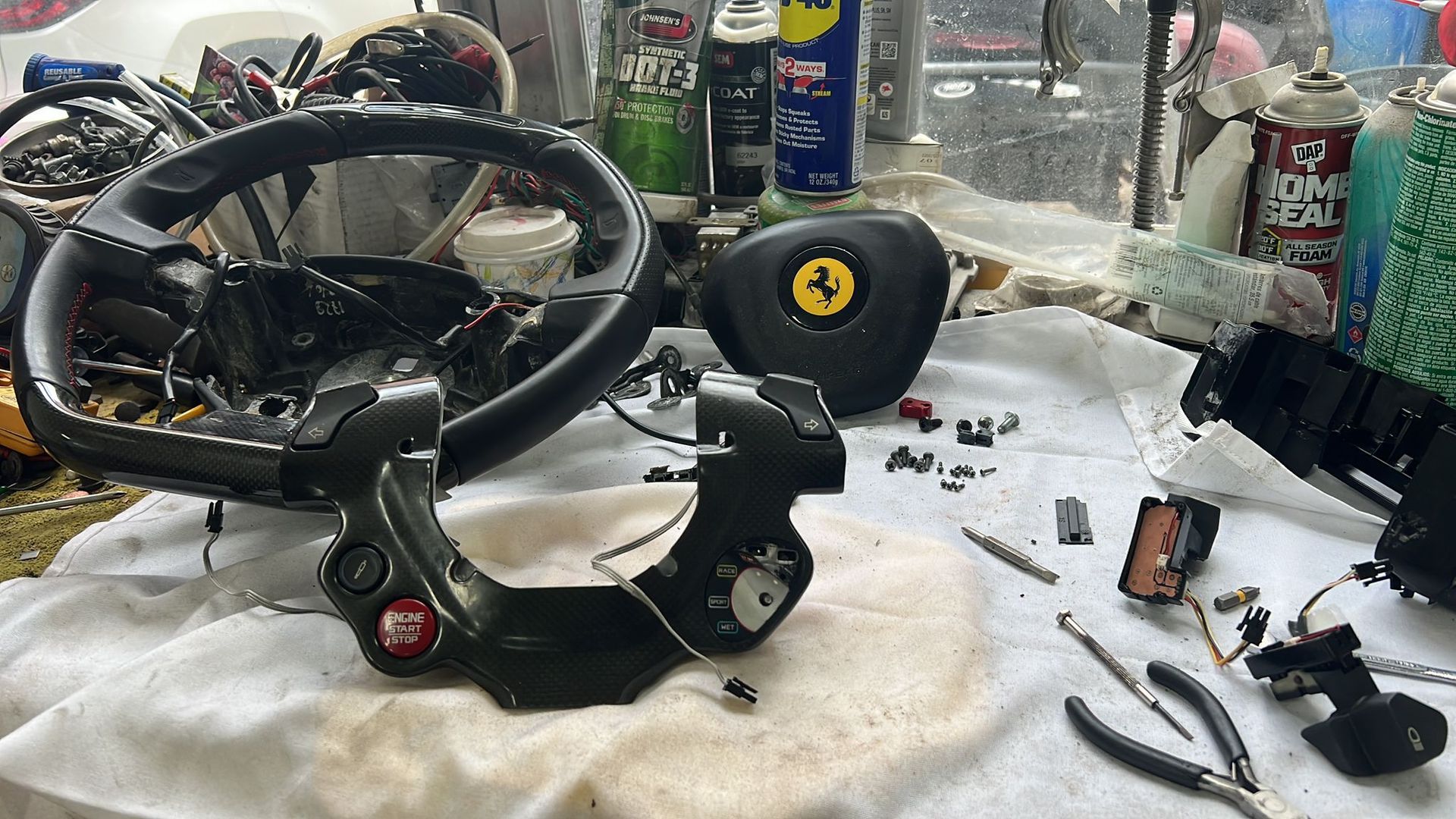 A steering wheel is sitting on top of a white towel on a table.